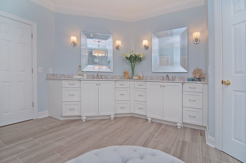 На фото: большая главная ванная комната в стиле неоклассика (современная классика) с фасадами в стиле шейкер, белыми фасадами, отдельно стоящей ванной, душем в нише, раздельным унитазом, серой плиткой, мраморной плиткой, синими стенами, полом из винила, врезной раковиной, мраморной столешницей, коричневым полом и душем с распашными дверями с