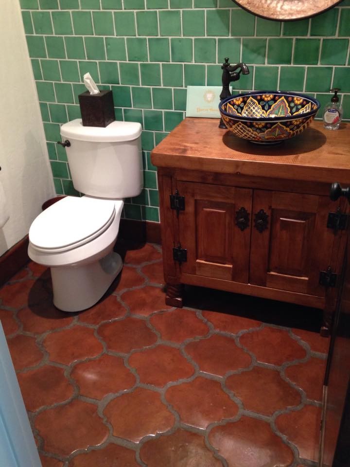 Inspiration pour une salle d'eau méditerranéenne en bois foncé de taille moyenne avec un placard en trompe-l'oeil, WC séparés, un carrelage vert, des carreaux de céramique, un mur blanc, tomettes au sol, une vasque, un plan de toilette en cuivre, un sol orange et un plan de toilette marron.