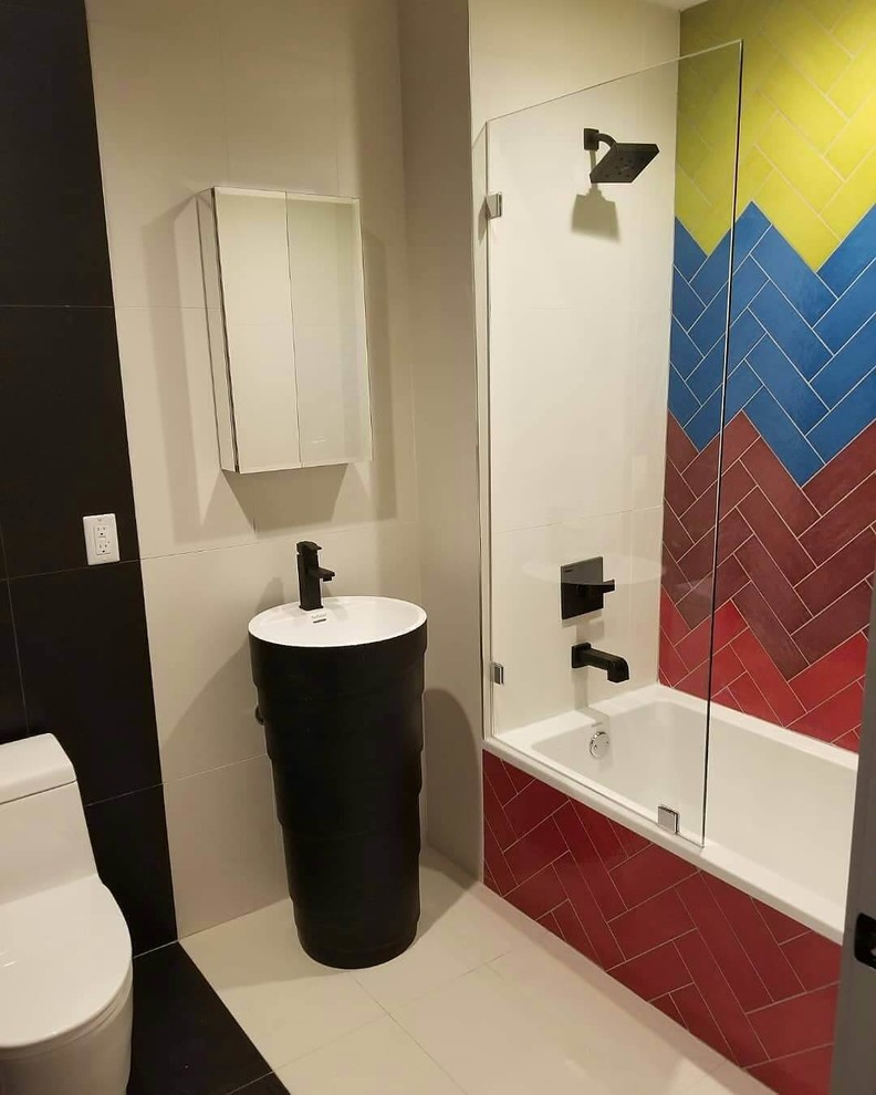 На фото: главная ванная комната среднего размера в современном стиле с черными фасадами, накладной ванной, душем над ванной, унитазом-моноблоком, разноцветной плиткой, керамической плиткой, разноцветными стенами, полом из керамической плитки, раковиной с пьедесталом, белым полом и душем с раздвижными дверями