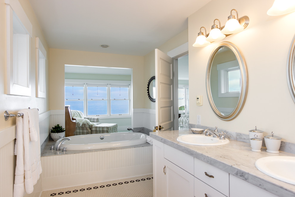 Стильный дизайн: большая главная ванная комната в морском стиле с накладной раковиной, белыми фасадами, мраморной столешницей, гидромассажной ванной, душем в нише, белой плиткой, керамической плиткой, желтыми стенами и полом из мозаичной плитки - последний тренд