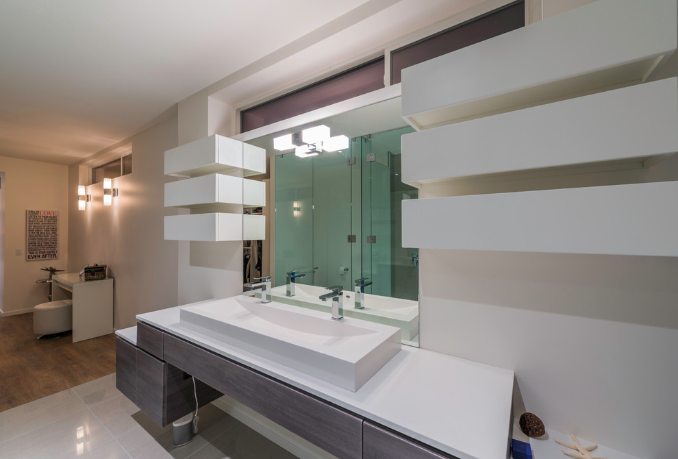 Пример оригинального дизайна: главная ванная комната в современном стиле с плоскими фасадами, темными деревянными фасадами, двойным душем, белыми стенами и раковиной с несколькими смесителями