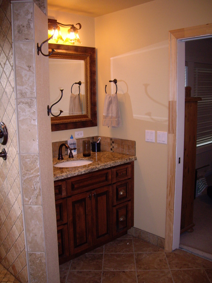 This is an example of a medium sized classic ensuite bathroom in Portland with a submerged sink, freestanding cabinets, dark wood cabinets, granite worktops, a double shower, a two-piece toilet, brown tiles, stone tiles, beige walls and travertine flooring.