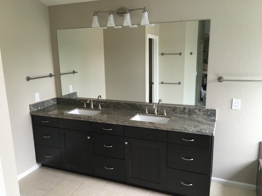 Imagen de cuarto de baño principal contemporáneo de tamaño medio con armarios estilo shaker, puertas de armario negras, lavabo bajoencimera y encimera de granito