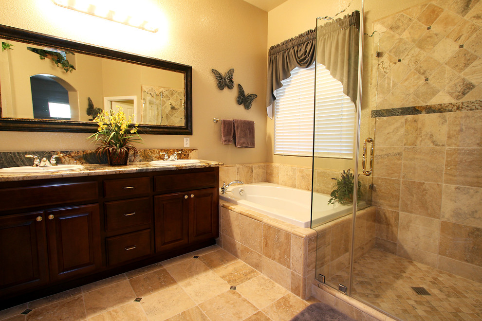Bathroom - traditional beige tile and stone tile bathroom idea in Sacramento with a drop-in sink, raised-panel cabinets, dark wood cabinets, granite countertops and black walls