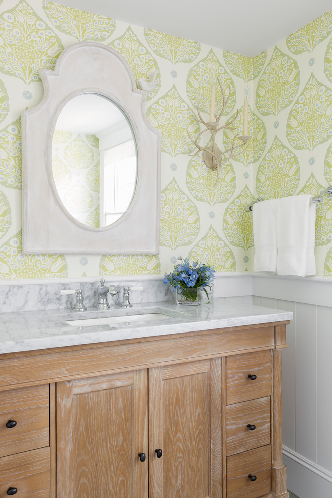 Cette photo montre une salle de bain bord de mer en bois brun avec un lavabo encastré, un placard à porte shaker et un mur multicolore.