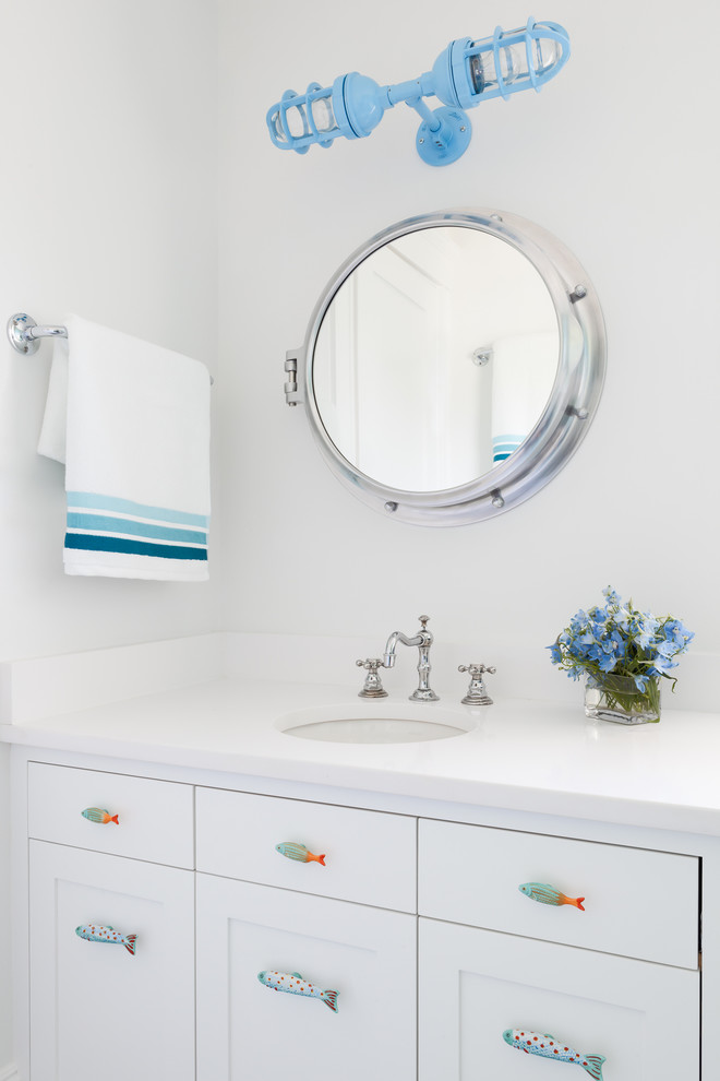 Foto de cuarto de baño marinero con lavabo bajoencimera, armarios estilo shaker, puertas de armario blancas y paredes blancas