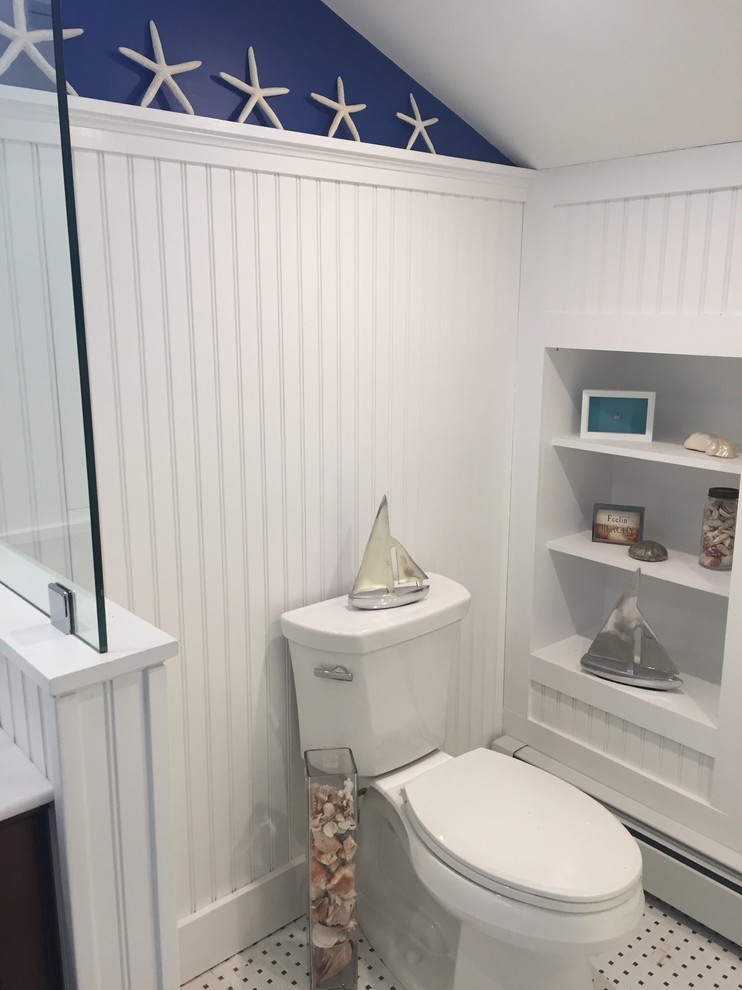 Cette image montre une salle de bain avec un mur bleu, un sol en carrelage de céramique et un plan de toilette en marbre.
