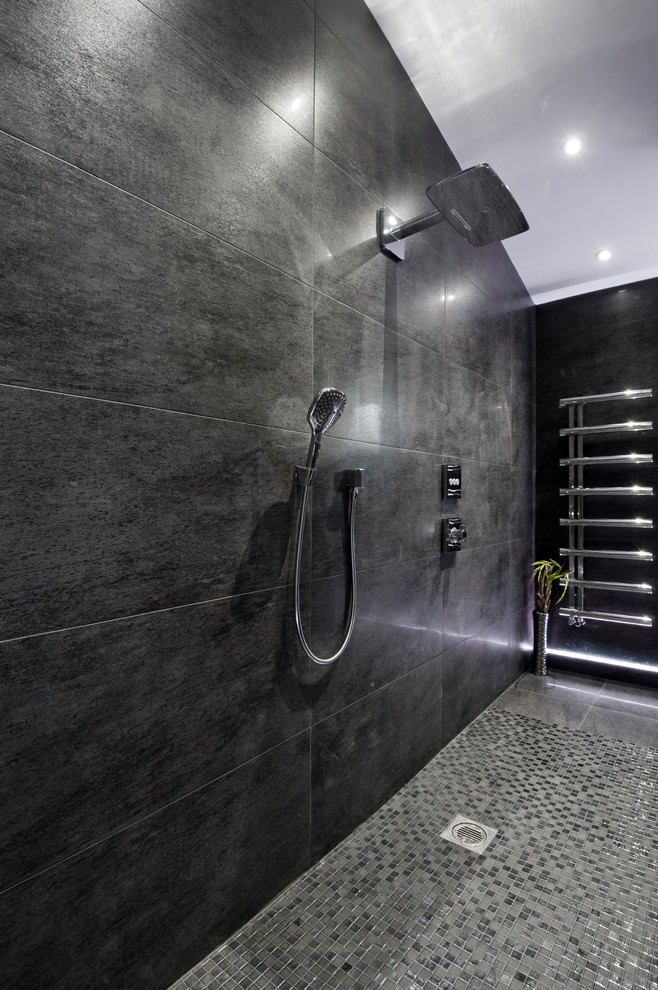 Large contemporary family bathroom in West Midlands with black cabinets, a freestanding bath, a walk-in shower, a wall mounted toilet, black tiles, grey walls, mosaic tile flooring, a built-in sink, black floors, an open shower and white worktops.