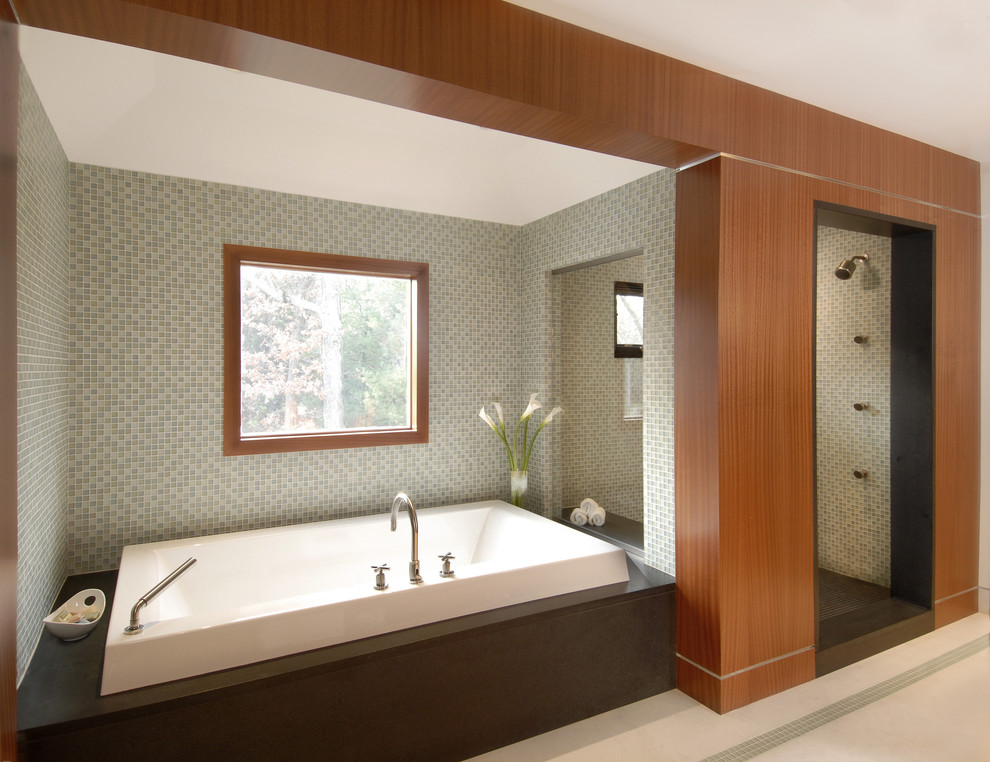 Свежая идея для дизайна: большая главная ванная комната в современном стиле с открытым душем, плоскими фасадами, фасадами цвета дерева среднего тона, накладной ванной, двойным душем, зеленой плиткой, стеклянной плиткой, зелеными стенами, полом из известняка и белым полом - отличное фото интерьера
