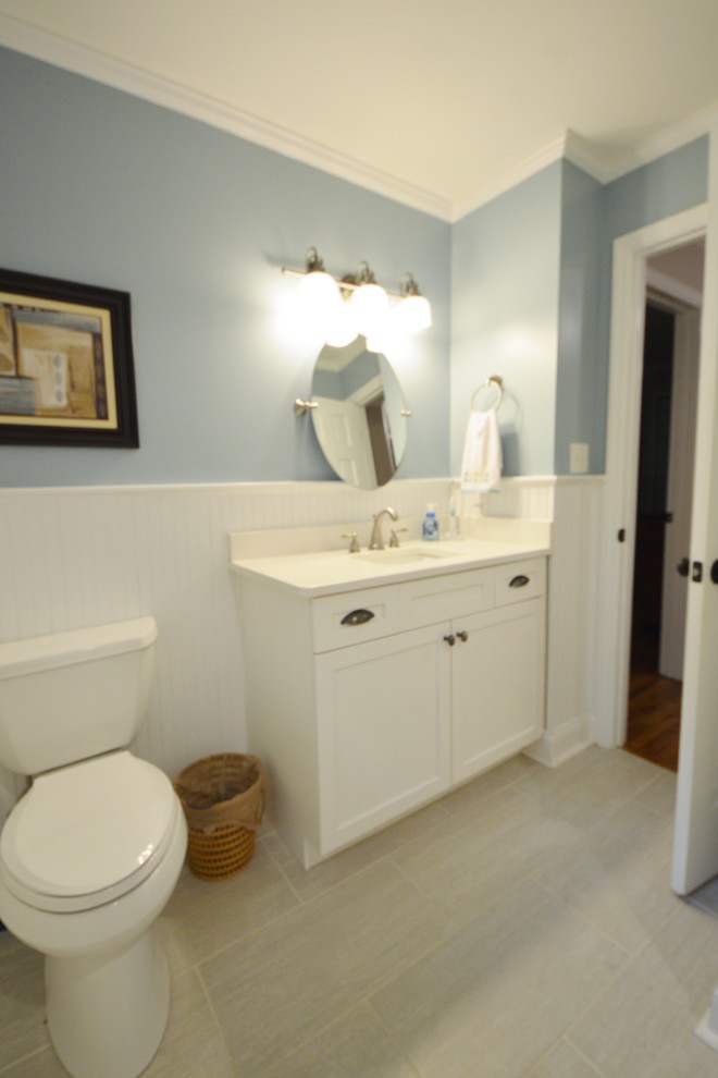 Maritimes Badezimmer En Suite mit Glasfronten, weißen Schränken, Duschbadewanne, weißen Fliesen, Keramikfliesen, blauer Wandfarbe und hellem Holzboden in Atlanta