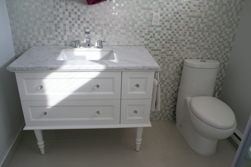 Bild på ett litet eklektiskt badrum, med möbel-liknande, vita skåp, marmorbänkskiva, grå kakel, en hörndusch, en toalettstol med hel cisternkåpa, ett undermonterad handfat, grå väggar och klinkergolv i porslin