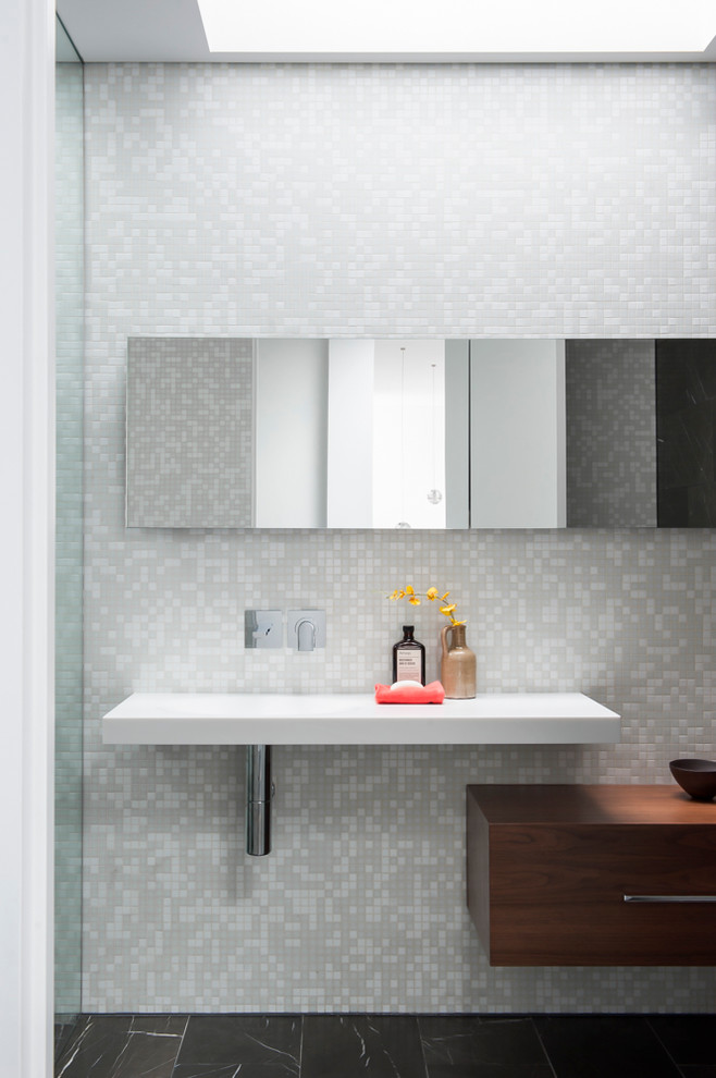 Cette photo montre une douche en alcôve tendance en bois foncé de taille moyenne avec un lavabo intégré, un placard à porte plane, un plan de toilette en surface solide, mosaïque, un sol en marbre et un carrelage gris.