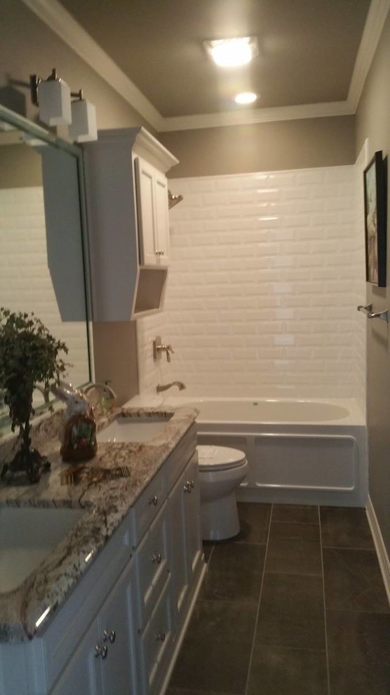Klassisk inredning av ett stort en-suite badrum, med luckor med infälld panel, vita skåp, ett badkar i en alkov, en dusch/badkar-kombination, vit kakel, tunnelbanekakel, bruna väggar, klinkergolv i porslin, ett undermonterad handfat, granitbänkskiva, grått golv och dusch med duschdraperi