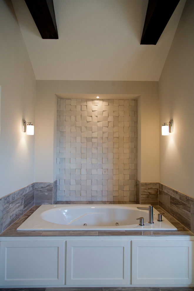 Large transitional master beige tile and stone tile drop-in bathtub photo in Kansas City