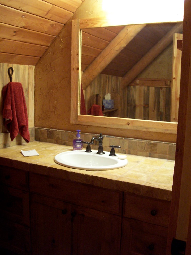 Foto di una grande stanza da bagno padronale rustica con lavabo da incasso, ante lisce, ante in legno scuro, top piastrellato, piastrelle beige, piastrelle in pietra e pareti beige