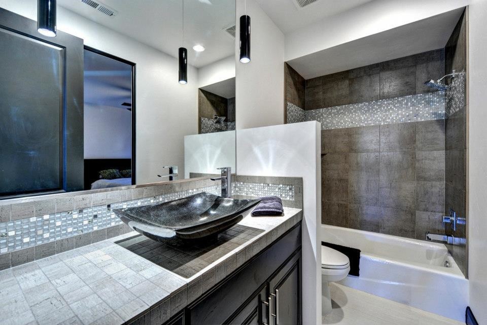 Пример оригинального дизайна: ванная комната среднего размера в современном стиле с фасадами с выступающей филенкой, темными деревянными фасадами, душем над ванной, черной плиткой, керамогранитной плиткой, серыми стенами, полом из керамогранита, настольной раковиной, столешницей из плитки и серым полом