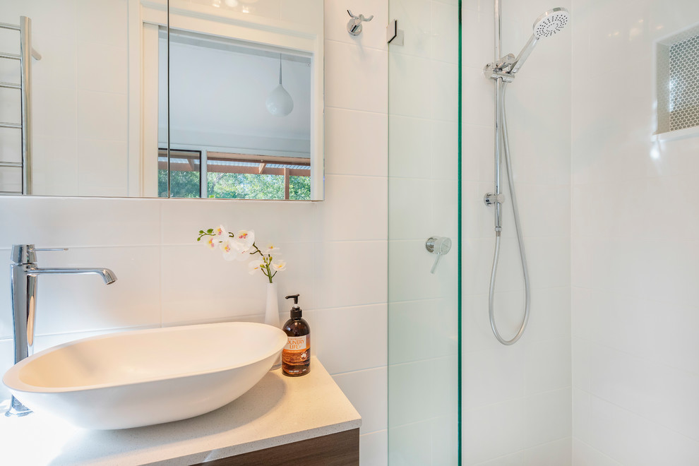 Photo of a medium sized contemporary ensuite bathroom in Sydney with raised-panel cabinets, light wood cabinets, a freestanding bath, a corner shower, a two-piece toilet, white tiles, ceramic tiles, white walls, porcelain flooring, a vessel sink, engineered stone worktops, multi-coloured floors, a hinged door and multi-coloured worktops.