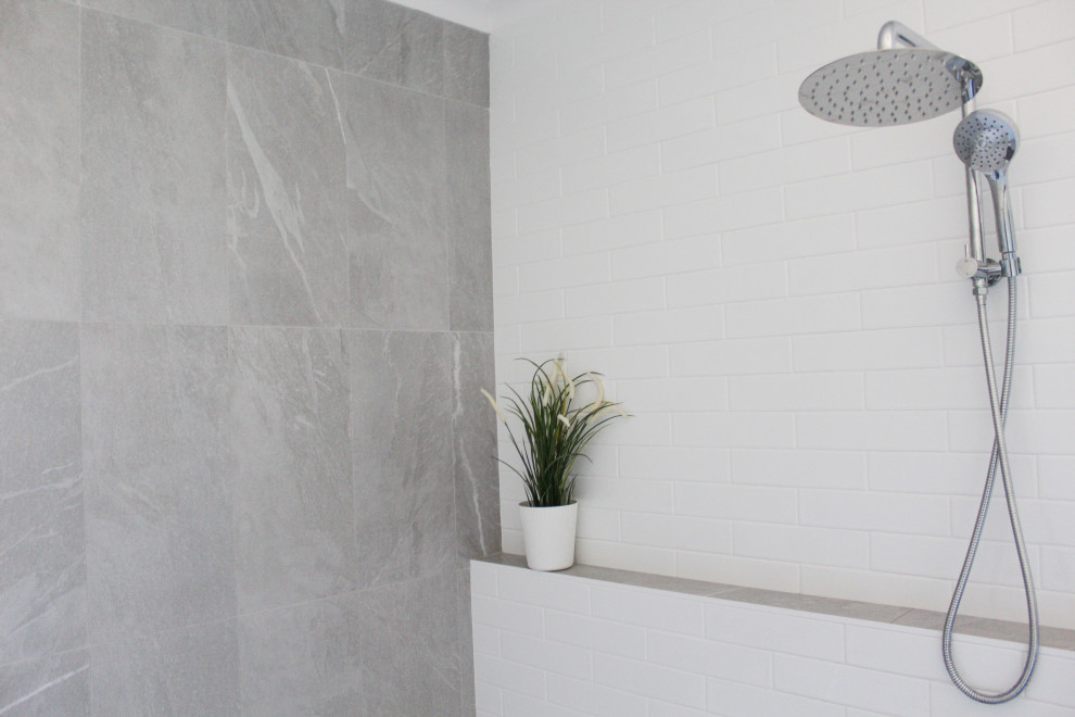 Пример оригинального дизайна: главная ванная комната среднего размера в стиле модернизм с плоскими фасадами, отдельно стоящей ванной, душевой комнатой, белой плиткой, керамической плиткой, белыми стенами, полом из керамогранита, настольной раковиной, серым полом, открытым душем и подвесной тумбой