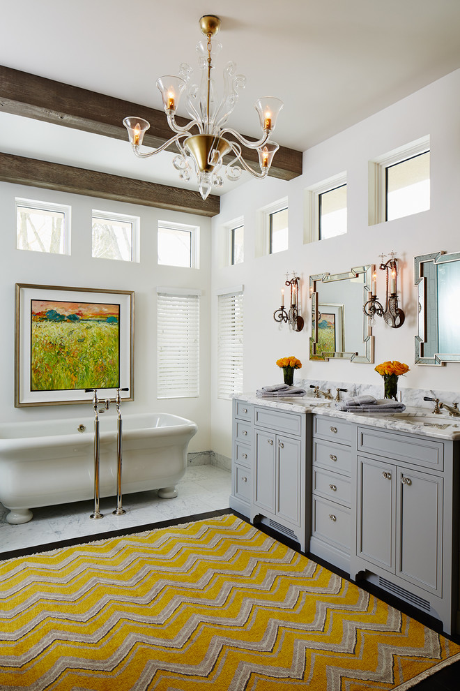 На фото: большая главная ванная комната в стиле неоклассика (современная классика) с серыми фасадами, отдельно стоящей ванной, фасадами с утопленной филенкой, белыми стенами, мраморным полом, врезной раковиной и мраморной столешницей с