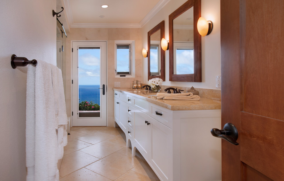 Example of a small arts and crafts beige tile and stone tile limestone floor and beige floor bathroom design in Los Angeles with an undermount sink, shaker cabinets, white cabinets, limestone countertops, a wall-mount toilet, white walls and a hinged shower door
