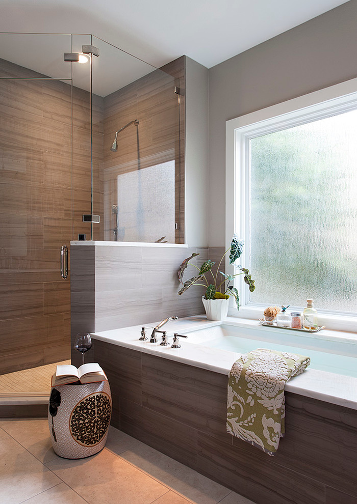 Large contemporary ensuite bathroom in Austin with brown tiles, a hinged door, flat-panel cabinets, brown cabinets, a built-in bath, a corner shower, a two-piece toilet, ceramic tiles, multi-coloured walls, ceramic flooring, a built-in sink, solid surface worktops and beige floors.