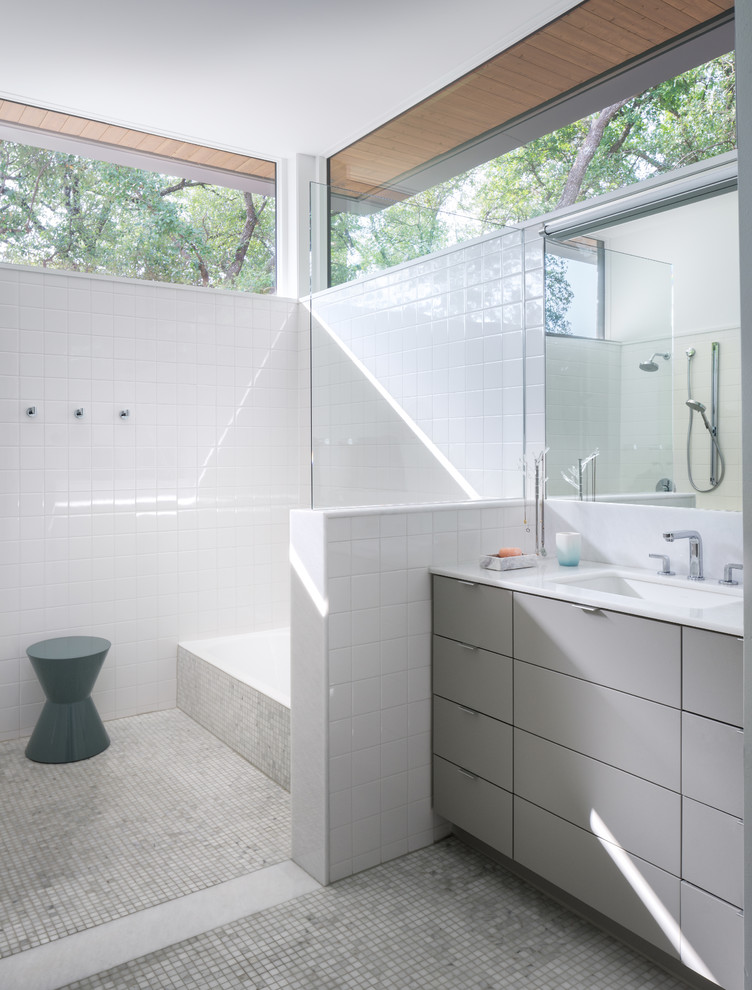 На фото: главная ванная комната среднего размера в современном стиле с плоскими фасадами, серыми фасадами, накладной ванной, белой плиткой, белыми стенами, полом из мозаичной плитки, серым полом, белой столешницей, душем без бортиков, врезной раковиной и открытым душем