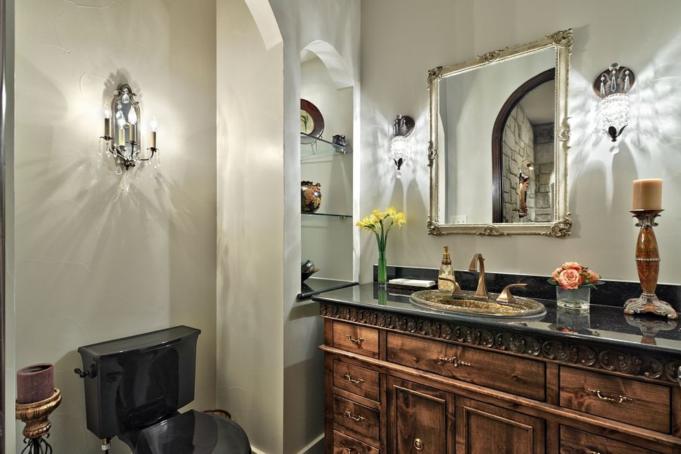 Modelo de cuarto de baño campestre con lavabo encastrado, armarios tipo mueble, puertas de armario con efecto envejecido, encimera de granito y paredes blancas