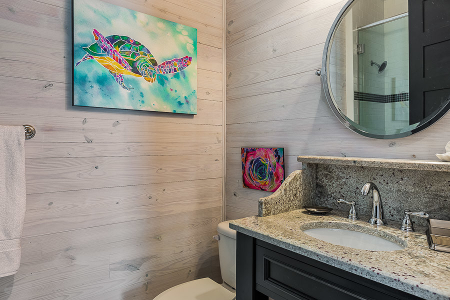 Exempel på ett mellanstort maritimt badrum med dusch, med ett undermonterad handfat, möbel-liknande, svarta skåp, granitbänkskiva, en toalettstol med separat cisternkåpa, beige väggar, en dusch i en alkov, flerfärgad kakel och keramikplattor