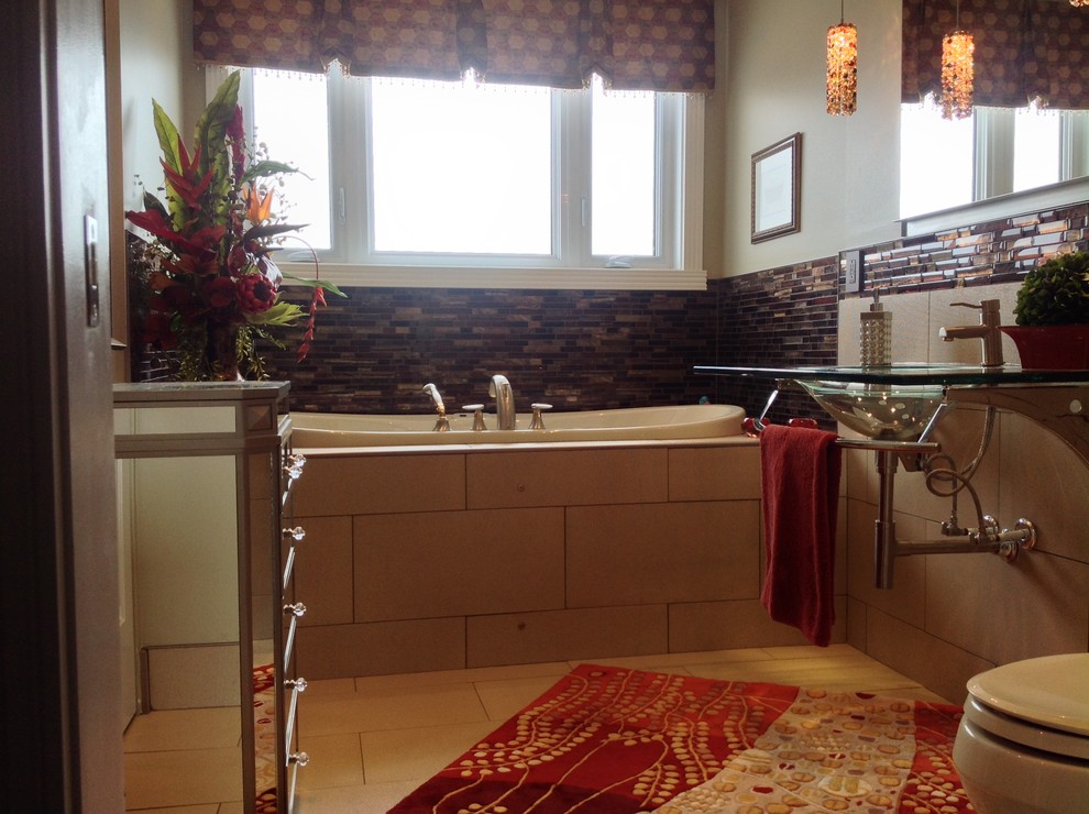 Ejemplo de cuarto de baño ecléctico con lavabo suspendido, encimera de vidrio, bañera encastrada, sanitario de una pieza y baldosas y/o azulejos marrones