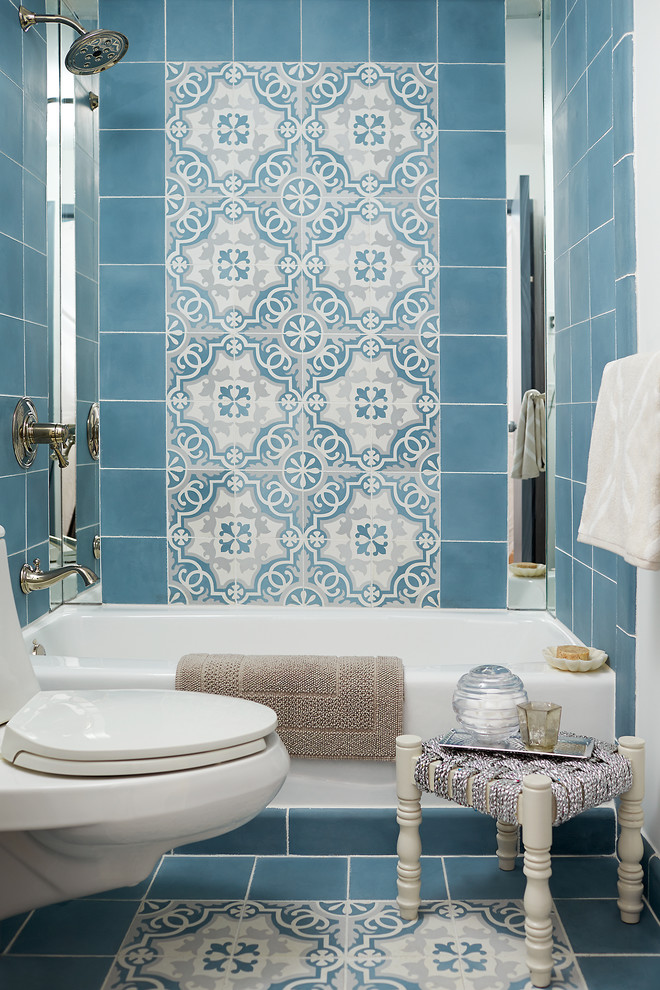 Inredning av ett modernt litet en-suite badrum, med ett platsbyggt badkar, en dusch/badkar-kombination, en toalettstol med hel cisternkåpa, blå kakel, cementkakel och vita väggar