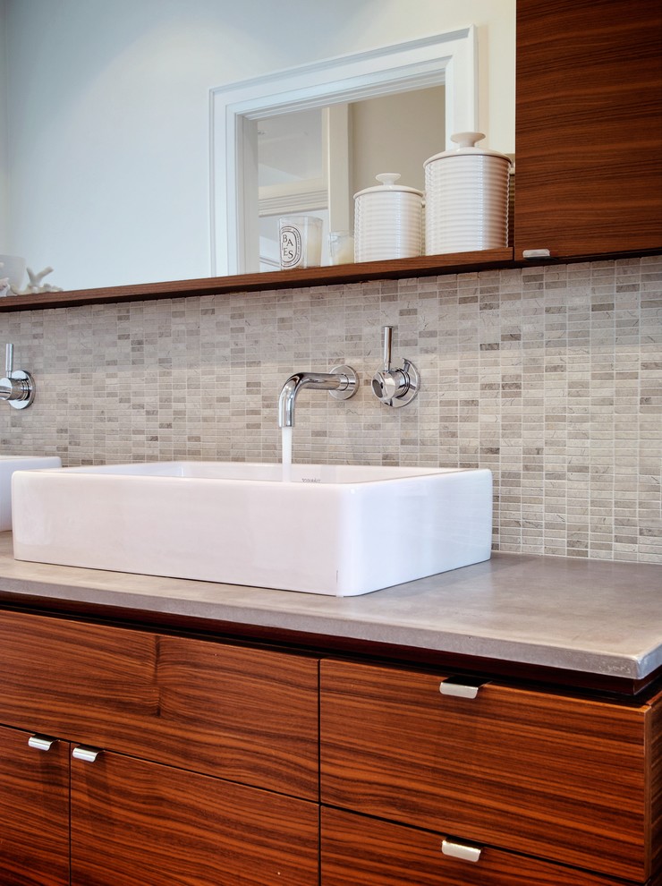 This is an example of a large modern ensuite bathroom in Toronto with flat-panel cabinets, medium wood cabinets, white walls, a vessel sink, concrete worktops and beige floors.