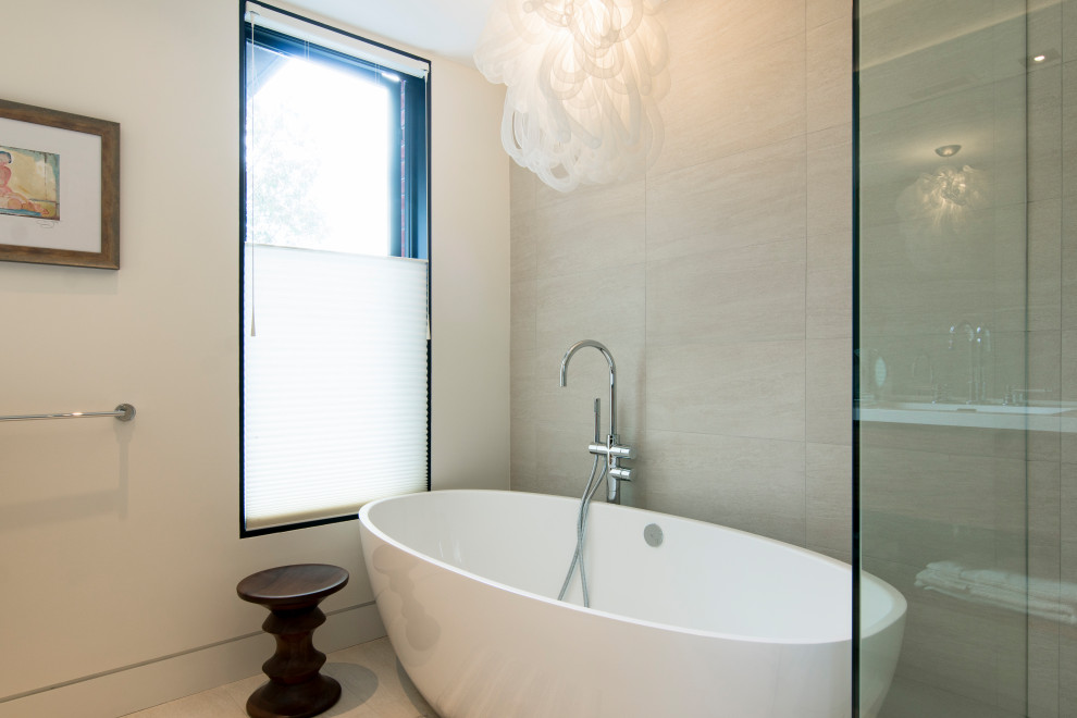 Medium sized modern ensuite bathroom in Toronto with flat-panel cabinets, medium wood cabinets, a freestanding bath, a walk-in shower, grey tiles, porcelain tiles, white walls, porcelain flooring, an integrated sink, engineered stone worktops, grey floors, a hinged door and white worktops.