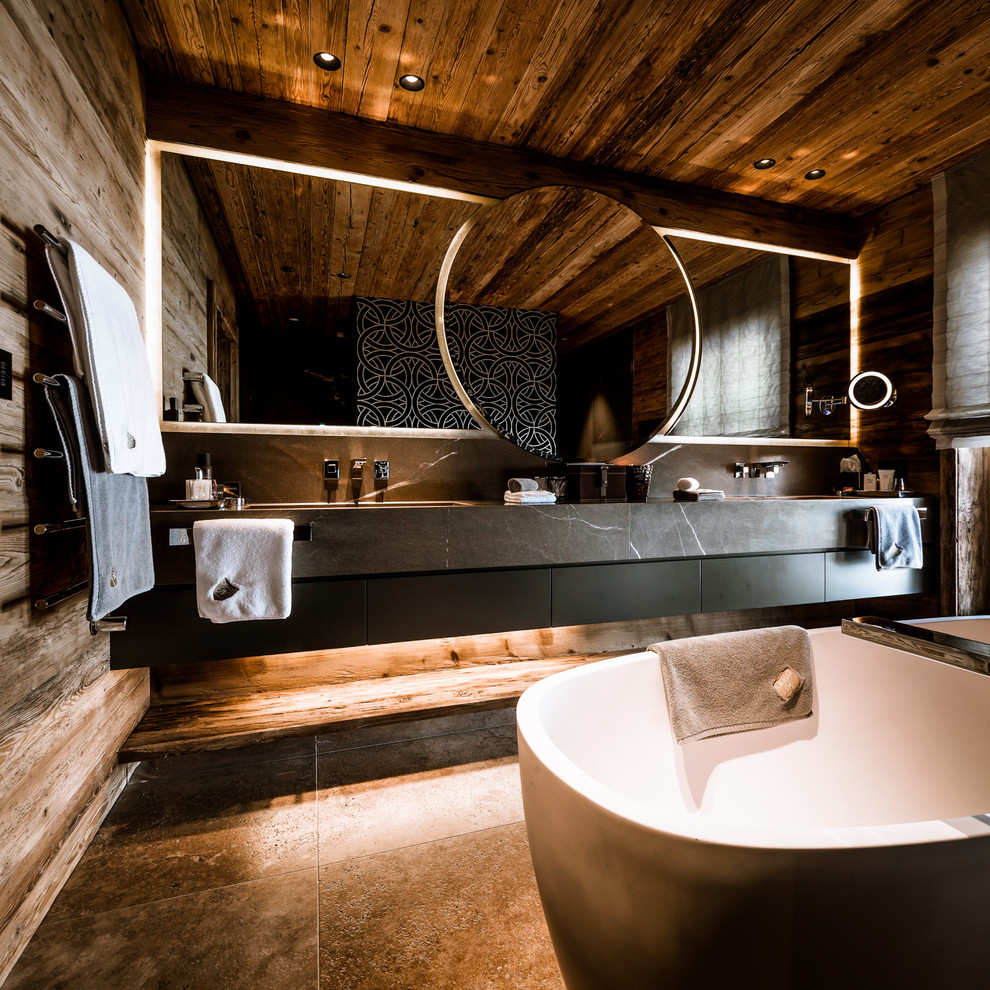 Идея дизайна: большая главная ванная комната в стиле рустика с монолитной раковиной, плоскими фасадами, черными фасадами, мраморной столешницей, отдельно стоящей ванной, черной плиткой, каменной плиткой и коричневыми стенами