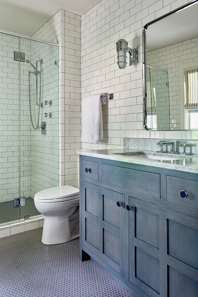 他の地域にあるラグジュアリーな中くらいなトランジショナルスタイルのおしゃれなバスルーム (浴槽なし) (シェーカースタイル扉のキャビネット、青いキャビネット、分離型トイレ、白いタイル、セラミックタイル、白い壁、大理石の床、アンダーカウンター洗面器、大理石の洗面台、青い床、コーナー設置型シャワー、開き戸のシャワー) の写真