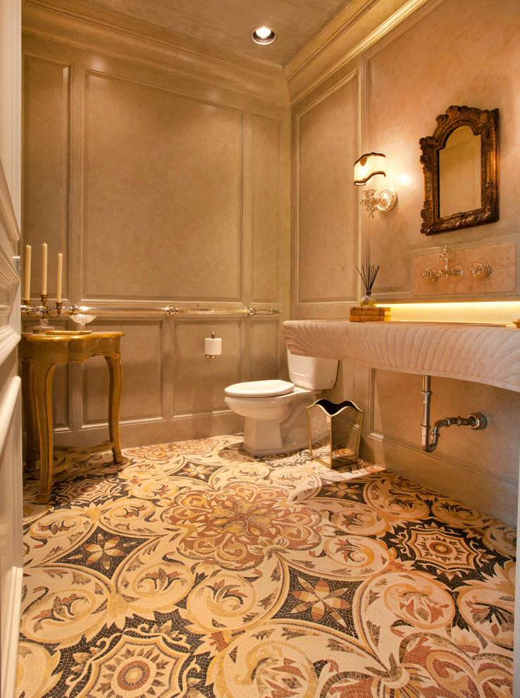 Пример оригинального дизайна: большая ванная комната в классическом стиле с монолитной раковиной, столешницей из известняка, полновстраиваемой ванной, раздельным унитазом, разноцветной плиткой, каменной плиткой, бежевыми стенами и полом из мозаичной плитки