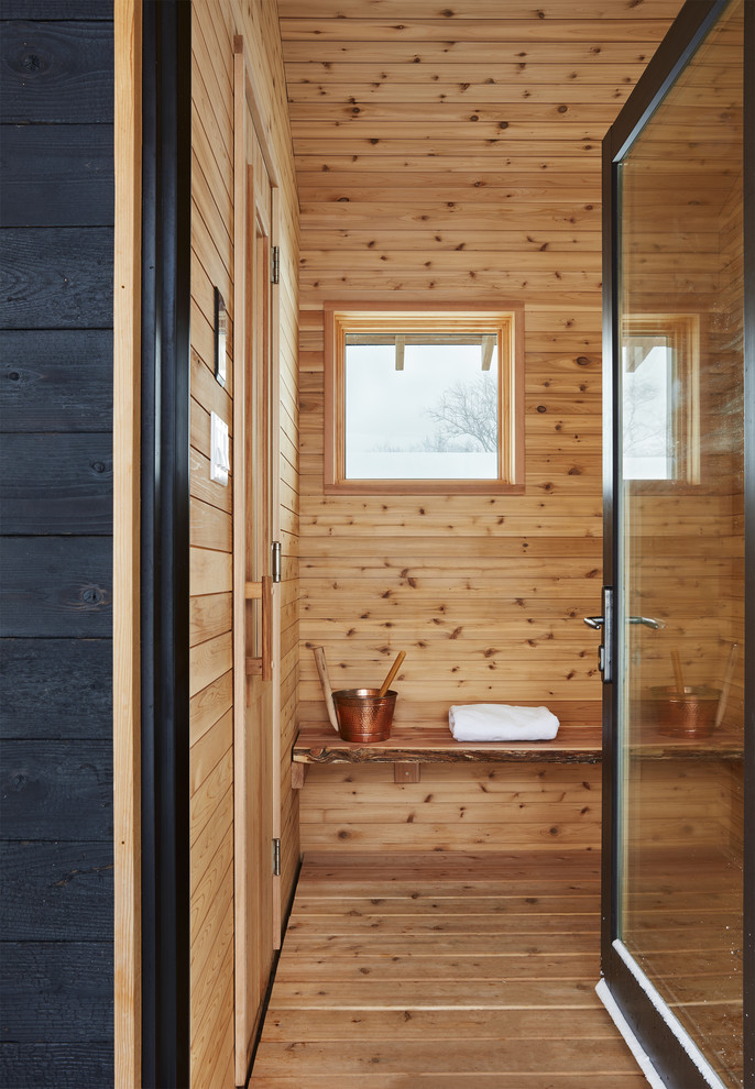 Réalisation d'un sauna nordique avec un mur marron, un sol en bois brun et un sol marron.
