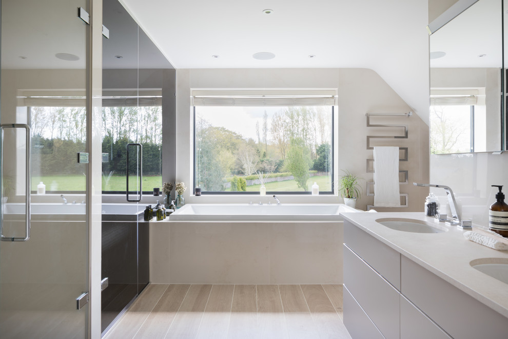 Design ideas for a large contemporary bathroom in London with flat-panel cabinets, white cabinets, a built-in bath, beige walls, a submerged sink, beige floors and beige worktops.