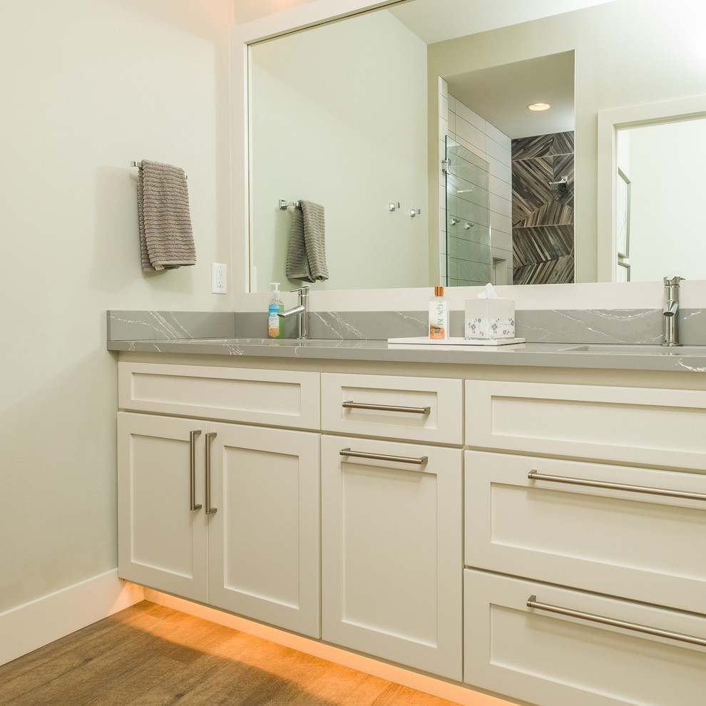 Mid-sized bathroom photo in Other with flat-panel cabinets, white cabinets, gray walls, an undermount sink, quartz countertops, a hinged shower door and gray countertops
