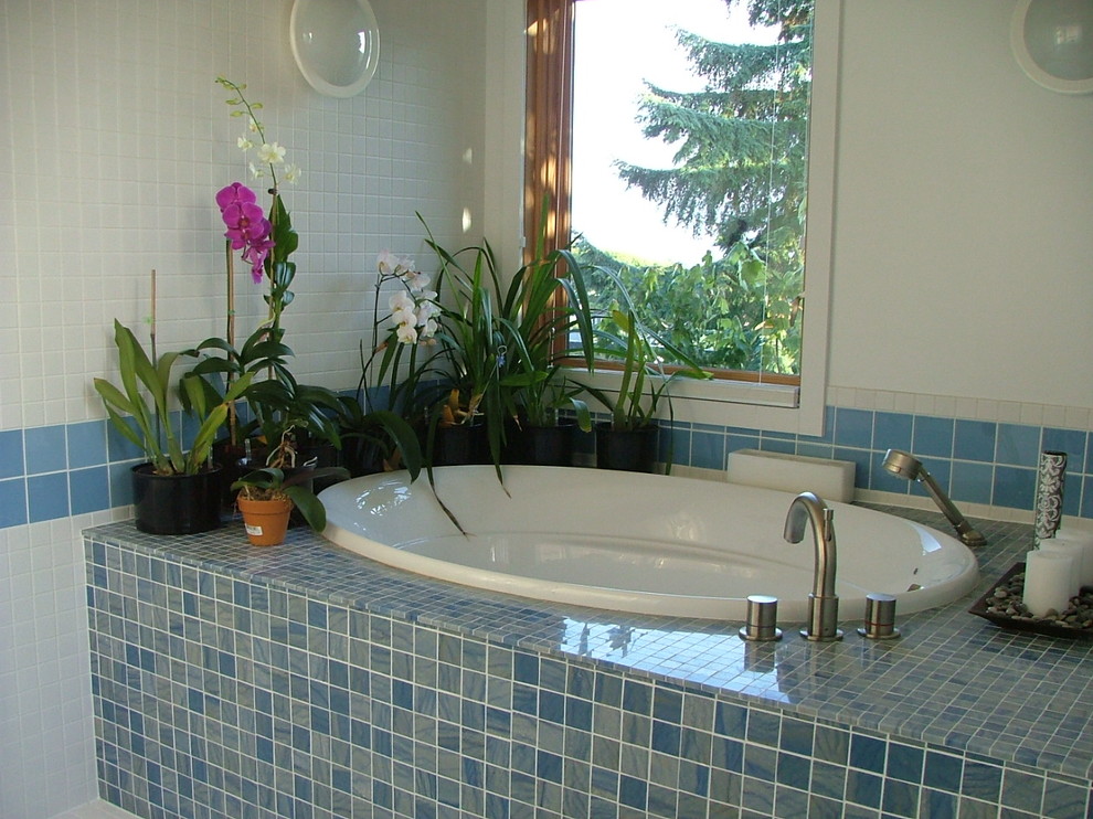 Diseño de cuarto de baño contemporáneo de tamaño medio con baldosas y/o azulejos azules, baldosas y/o azulejos blancos, baldosas y/o azulejos de porcelana, bañera esquinera, paredes blancas y suelo de baldosas de porcelana