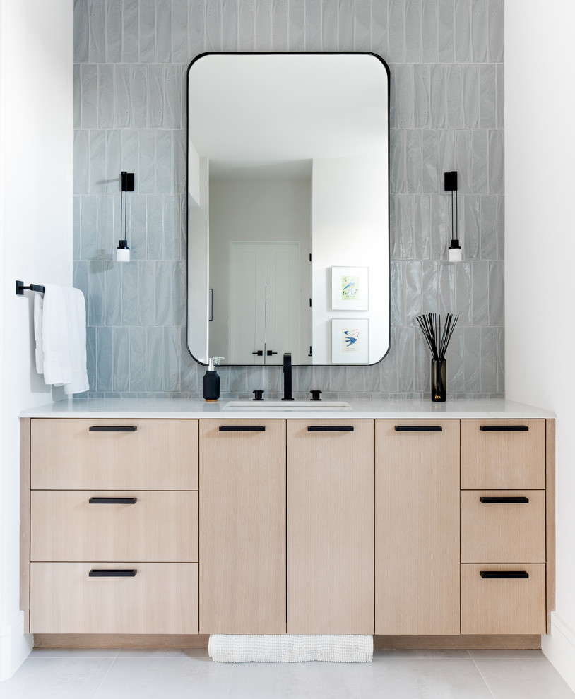 Ejemplo de cuarto de baño contemporáneo con armarios con paneles lisos, puertas de armario de madera clara, baldosas y/o azulejos grises, paredes blancas, lavabo bajoencimera, suelo gris y encimeras blancas
