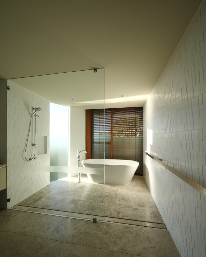 This is an example of an expansive contemporary family bathroom in Brisbane with white tiles and white walls.