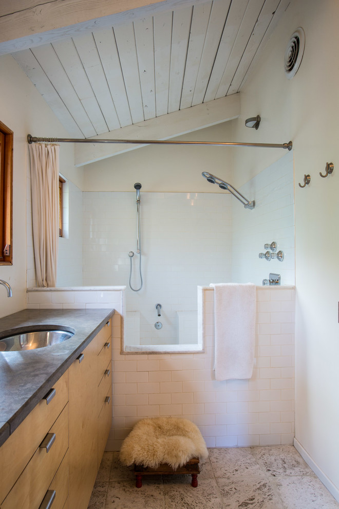 Пример оригинального дизайна: ванная комната в современном стиле с врезной раковиной, плоскими фасадами, фасадами цвета дерева среднего тона, ванной в нише, душем над ванной, белой плиткой и плиткой кабанчик