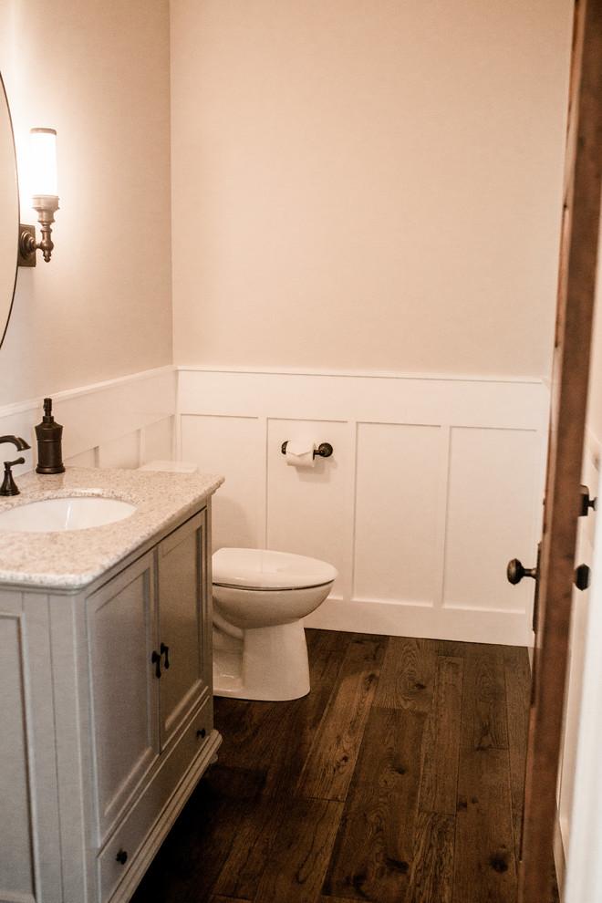 Example of a mid-sized trendy 3/4 beige tile dark wood floor and brown floor bathroom design in Seattle with a one-piece toilet, a drop-in sink and granite countertops