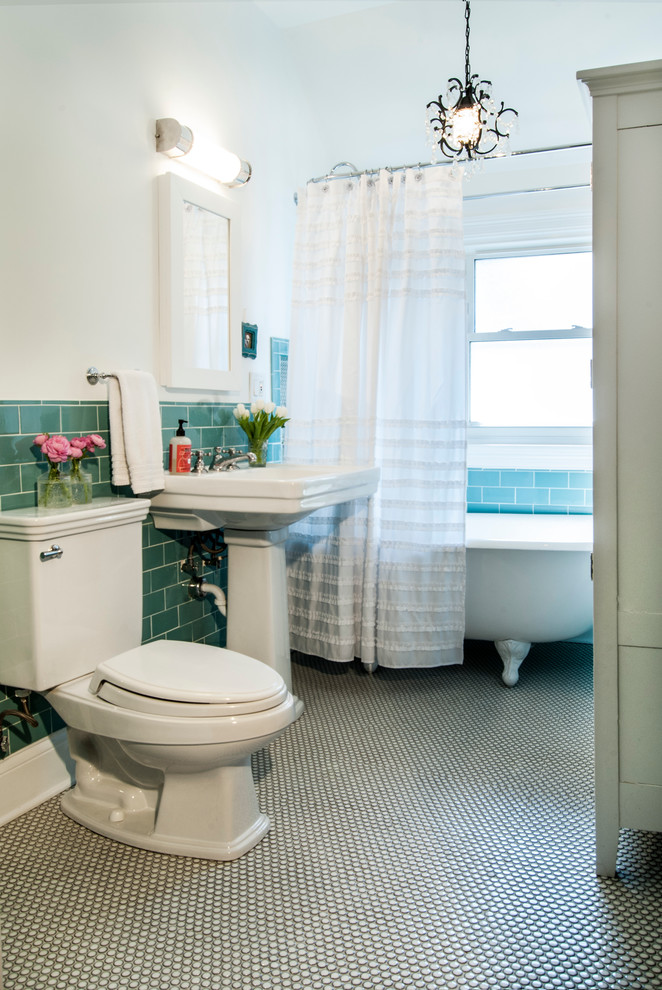 Inredning av ett klassiskt badrum, med ett piedestal handfat, ett badkar med tassar, en dusch/badkar-kombination, blå kakel, tunnelbanekakel och mosaikgolv