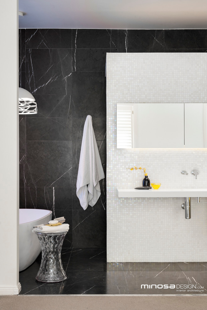 Exempel på ett modernt badrum, med ett integrerad handfat, ett fristående badkar, en öppen dusch, en toalettstol med hel cisternkåpa, luckor med infälld panel, bänkskiva i akrylsten, grå kakel och mosaik