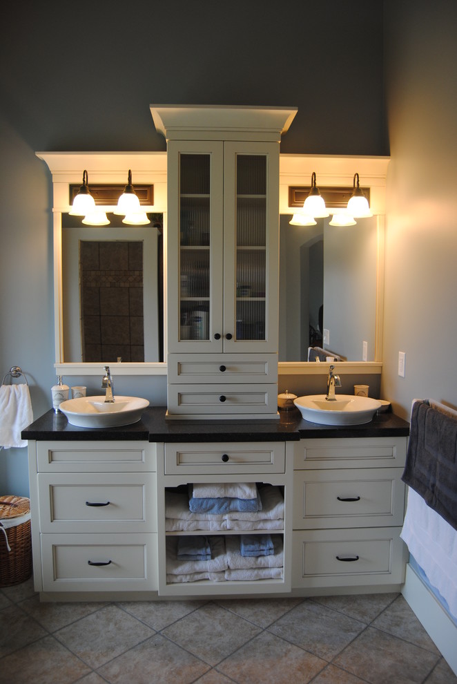 Diseño de cuarto de baño clásico con lavabo sobreencimera, armarios tipo mueble, puertas de armario blancas y encimera de cuarzo compacto