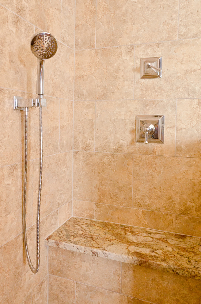 This is an example of a large classic ensuite bathroom in Chicago with recessed-panel cabinets, medium wood cabinets, a double shower, a two-piece toilet, beige tiles, stone tiles, beige walls, travertine flooring, a submerged sink and granite worktops.