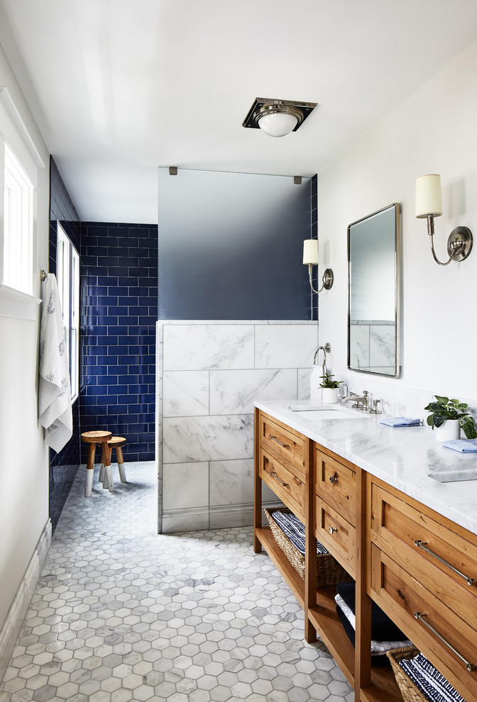 Idéer för maritima vitt badrum, med skåp i mellenmörkt trä, en kantlös dusch, blå kakel, tunnelbanekakel, vita väggar, ett undermonterad handfat, vitt golv, med dusch som är öppen och skåp i shakerstil