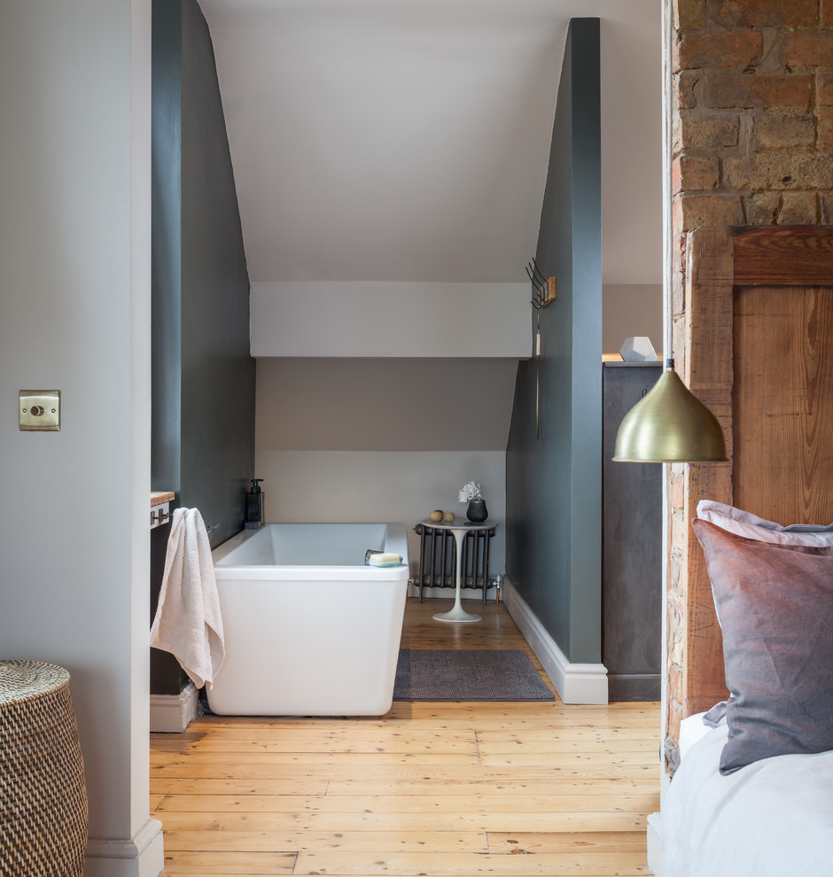 Exempel på ett mellanstort klassiskt en-suite badrum, med grå väggar, ljust trägolv och ett fristående badkar