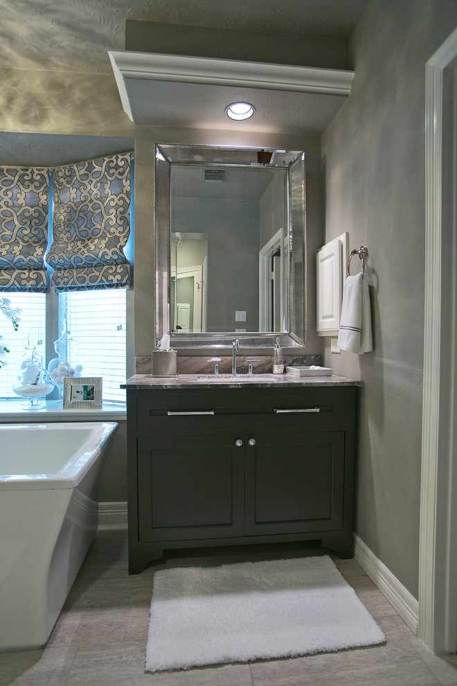 Design ideas for a classic bathroom in Houston with a submerged sink, freestanding cabinets, black cabinets, marble worktops, a freestanding bath, a built-in shower, a one-piece toilet, grey tiles and ceramic tiles.